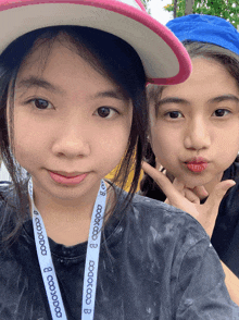 two girls are posing for a picture and one has a lanyard around her neck that says aoaoaoaoao