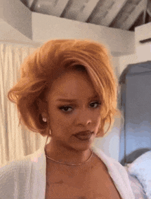 a woman with red hair is wearing a white top