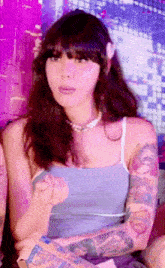 a woman with a lot of tattoos on her arms is wearing a blue top