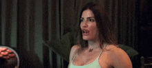 a woman is laughing and clapping her hands at a party while wearing a bikini top .