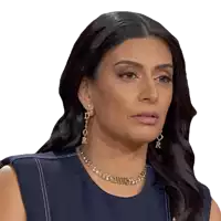 a woman wearing a dior necklace and earrings looks serious