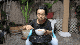 a woman sitting on a stool eating cereal from a bowl