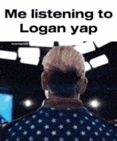 a man in an american flag jacket is listening to logan yap on a stage .