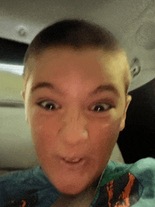 a young boy is making a funny face with his eyes closed