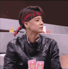 a woman wearing a leather jacket and a red headband