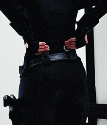 a woman with her hands on her hips is wearing a black outfit