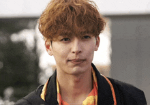 a close up of a man 's face with curly hair