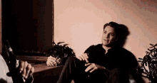 a man is sitting on the floor holding a bottle of beer
