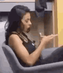 a woman is sitting in a chair eating a piece of food .