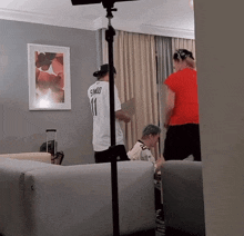 a man wearing a number 11 shirt stands in a living room