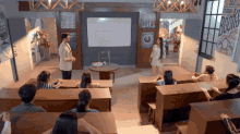 a group of people in a classroom with a sign on the wall that says ' books '