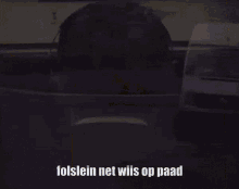 a man wearing headphones looks out a window and says folslein net wiis op paad .