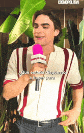 a man holding a pink cosmopolitan microphone in his hand