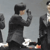 a man in a suit takes a picture of another man