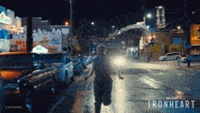 a person running down a street with ironheart written on the side