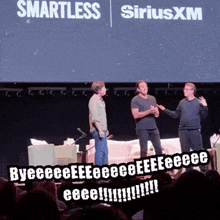 three men standing on a stage in front of a siriusxm sign