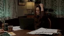 a woman sitting at a desk with a laptop and a citytv logo on the bottom