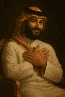 a man with a beard is sitting in a chair with his hand on his chest