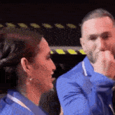 a man and a woman are standing next to each other and talking .
