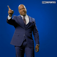 a man in a suit is pointing at the camera with fox deportes written on the bottom