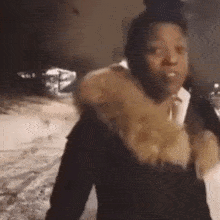a woman is standing in the snow wearing a fur coat and looking at the camera .