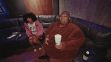 a man is holding a cup that says purple stuff on it