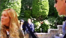 a man and a woman are standing next to each other in a park ..