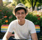a young man wearing a hat and glasses smiles for the camera