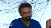 a man with a beard is wearing a blue shirt that says ' la palapa externa ' on it