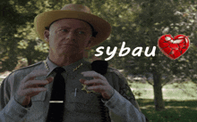 a man in a sheriff 's uniform is holding a microphone and the word sybau is written above him
