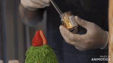 a person is holding a jar of gold sprinkles and a strawberry on top of a cake that is made in animatica