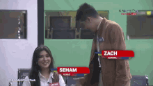 a man and a woman are sitting next to each other and the man 's name is zach aurora