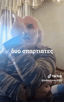 a man with a beard is sitting on a couch with a blue light behind him and a tiktok watermark