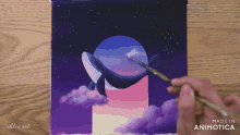 a person is painting a whale with a brush and the words made in animatica are visible