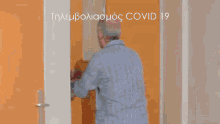 a man in pajamas is dancing in front of a door with the words covid 19 written above him