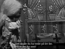 a black and white photo of a woman holding a baby with the words det skulle du ha tenkt på litt for na er det for sent