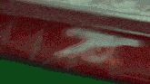 a blurred image of a gun on a red brick wall