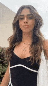 a woman wearing a black and white dress and a necklace .