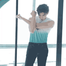 a man in a blue and white sleeveless shirt is stretching his arms