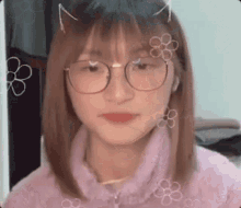 a girl wearing glasses and a purple sweater is looking at the camera .