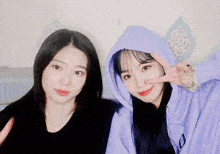 two girls are posing for a picture and one has the letter d on her sweatshirt
