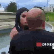 a man kissing a woman on the cheek in front of a sign that says expo