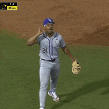a baseball player with the number 24 on his jersey stands on the field