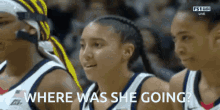 a group of female basketball players are watching a game and one of them is asking where was she going