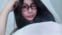 a girl wearing glasses and a white blanket