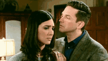 a man and a woman are looking at each other in a living room .