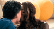 a man and woman kissing in front of balloons