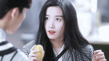 a woman with long black hair is holding a yellow object in her hand