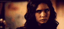 a close up of a woman 's face with a serious look on it .