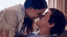 a woman kisses a man on the forehead in a room